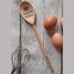 A regal wooden spoon fit for a king of the kitchen. The spoon is meticulously carved from smooth, polished wood, showcasing its elegant craftsmanship. Its long handle provides a comfortable grip, while the wide, curved bowl at the end is perfect for stirring, mixing, and tasting culinary creations. The spoon's rich, warm color and fine grains exude a sense of natural beauty and durability. It is an essential tool for any royal chef, symbolizing tradition, quality, and the artistry of culinary mastery."