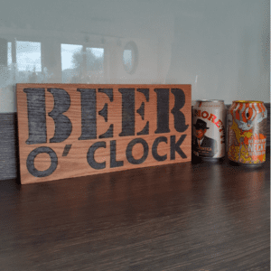 oak wood sign with hand burnt text saying 'beer o'clock'