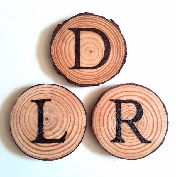 Handcrafted burnt wood slice coasters featuring personalized initials. The coasters are made from natural wood slices with unique patterns and textures. Each coaster showcases elegantly burnt initials, adding a personalized touch to your home decor. The dark, smoky hues of the burnt wood create a rustic and earthy aesthetic, while the smooth surface ensures a sturdy and protective base for your drinks. These coasters are not only functional but also serve as eye-catching decorative accents, bringing a touch of nature-inspired charm to any tabletop.