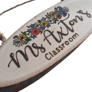 handmade wooden personalised log plaque with hand burnt teacher name and a colourful floral design