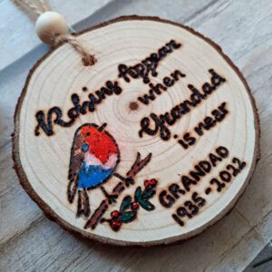 handmade wooden memorial christmas ornament with a festive robin design. Personalised with a name or family member of years of their life.