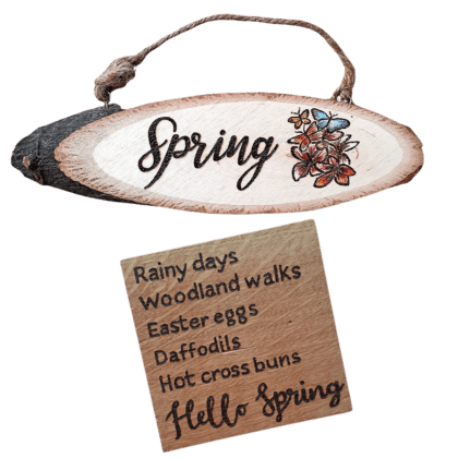 A square wooden coaster featuring intricate oak woodwork with the words 'Hello Spring' engraved on the surface in elegant script. The coaster is handcrafted with attention to detail, showcasing the warmth and natural beauty of wood grain. An oval rustic plaque with hand burnt design for Spring decor