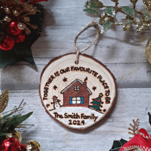 A festive Christmas tree ornament with a rustic design. The ornament features a charming house motif and a heartwarming message that reads, "Together is our favourite place to be - 2024