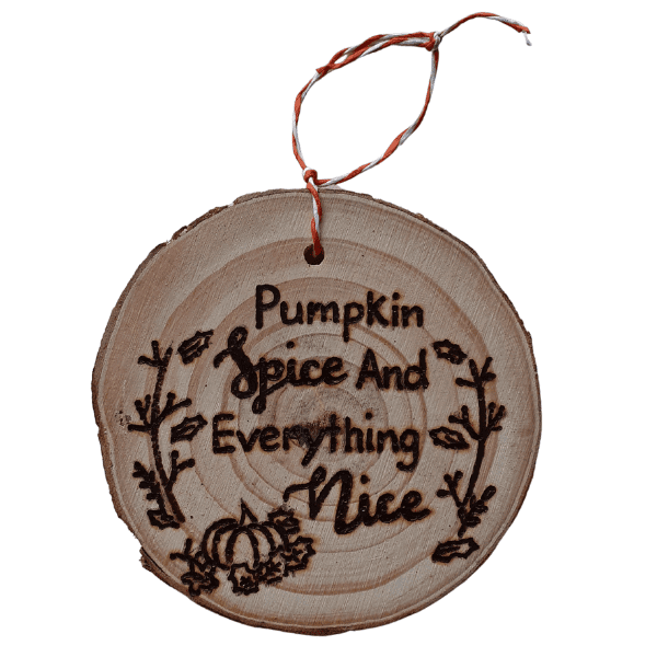 rustic wood hanging slice with hand burnt text saying 'pumpkin slice and everything nice'. Also has an autumn wreath and pumpkin design around the edge