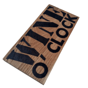 oak wood sign with hand burnt text saying 'wine o'clock'