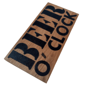 oak wood sign with hand burnt text saying 'beer o'clock'