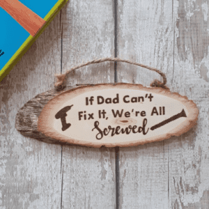 A hand-burnt rustic oval plaque featuring a humorous phrase: "If dad can't fix it, we are all screwed."