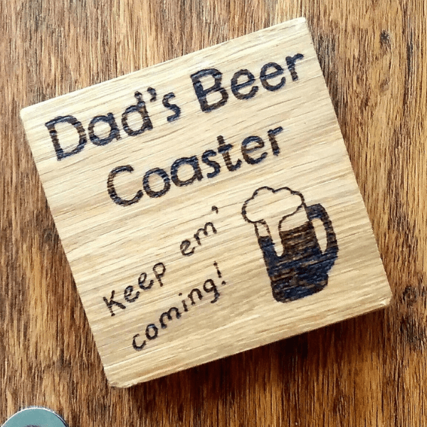 A solid oak coaster designed for a beer. The coaster is square in shape and made from high-quality oak wood. It features a smooth surface with a natural wood grain pattern. The coaster is sturdy and durable, providing a reliable surface to rest a beer glass upon. Its neutral brown color complements any decor and adds a touch of rustic elegance to the table. A practical and stylish accessory for beer enthusiasts and those who appreciate artisanal craftsmanship."