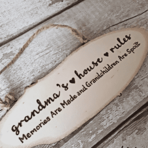 "An oval, hand-burnt rustic plaque with the following inscription: 'Grandma's House Rules, where memories are made and grandchildren are spoiled.'"