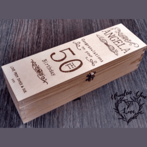 A personalized wooden wine box with a rustic charm. The box is made from high-quality wood and features a hinged lid. The lid is engraved with a custom message, adding a personal touch to the gift. The wine box is an ideal gift for wine enthusiasts and special occasions, allowing for a memorable and sophisticated presentation of their favorite bottles."