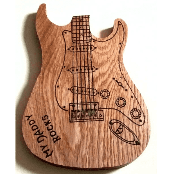 A personalized oak serving and chopping board shaped like a guitar. The wooden board features the silhouette of a guitar, with a curved body, a long neck, and tuning pegs. It is made from high-quality oak, giving it a beautiful grain pattern and a smooth finish. The board is personalized with the name [insert name here], carved into the wood near the body of the guitar. This unique and functional piece would make a great gift for music lovers or anyone who appreciates creative kitchenware."