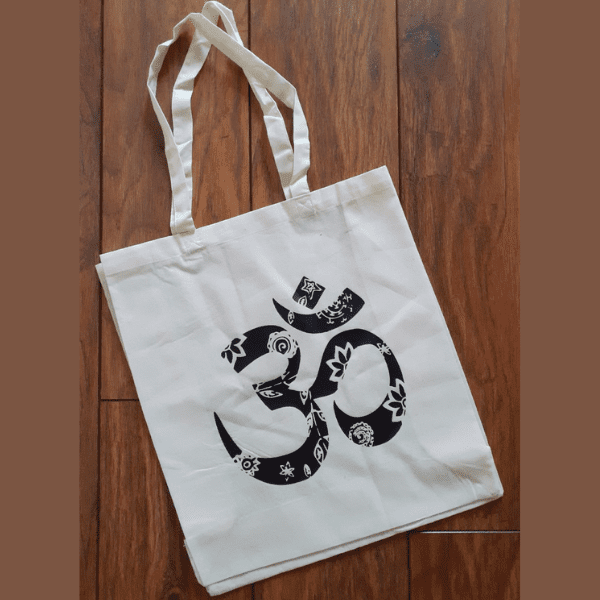 "A natural tote bag featuring a black Aum symbol and intricate mandala design."